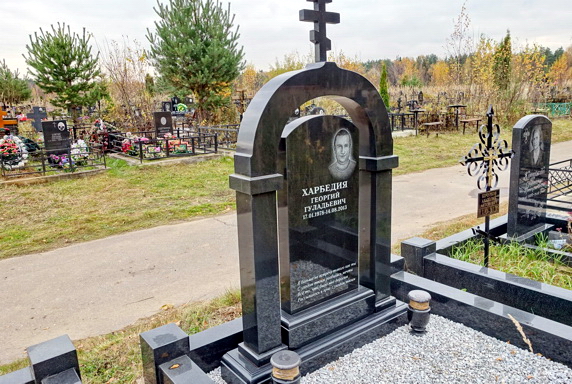 Надгробье классической формы и окаймляющая его арка